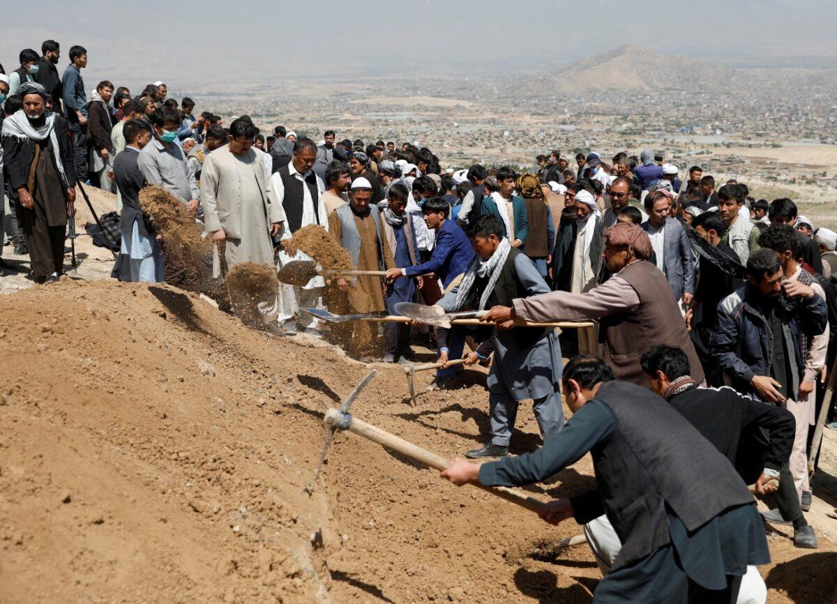 Men dig graves for the victims of a May 8 explosion during a mass funeral ceremony in Kabul, Afghanistan, on May 9, 2021. (Stringer/Reuters)