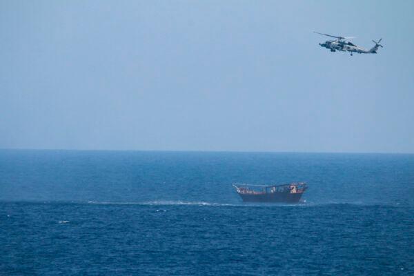 A U.S. Navy Seahawk helicopter flies over a stateless dhow later found to be carrying a hidden arms shipment in the Arabian Sea, on May 6, 2021.(U.S. Navy via AP)