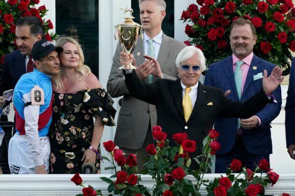Jockey John Velazquez (L) watches as trainer Bob Baffert holds up the winner's trophy after they victory with Medina Spirit in the 147th running of the Kentucky Derby at Churchill Downs, in Louisville, Ky., on May 1, 2021. (Jeff Roberson/AP Photo)