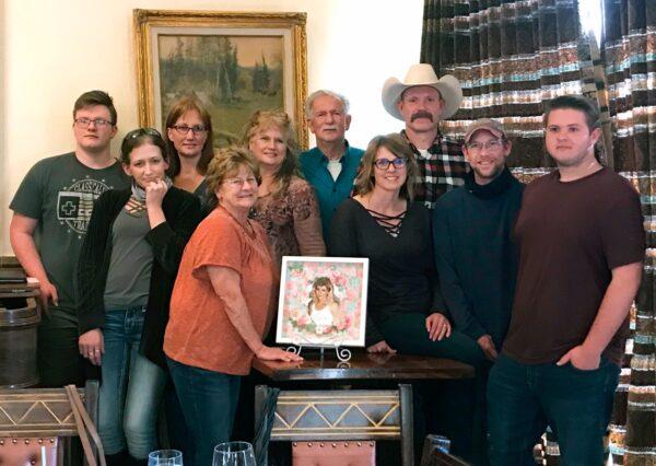 Members of the Pitts family surround a photo of Pamela Pitts, who was killed in 1988 outside Prescott, Ariz., in a photo taken on March 1, 2021. (Susan Eazer via AP)