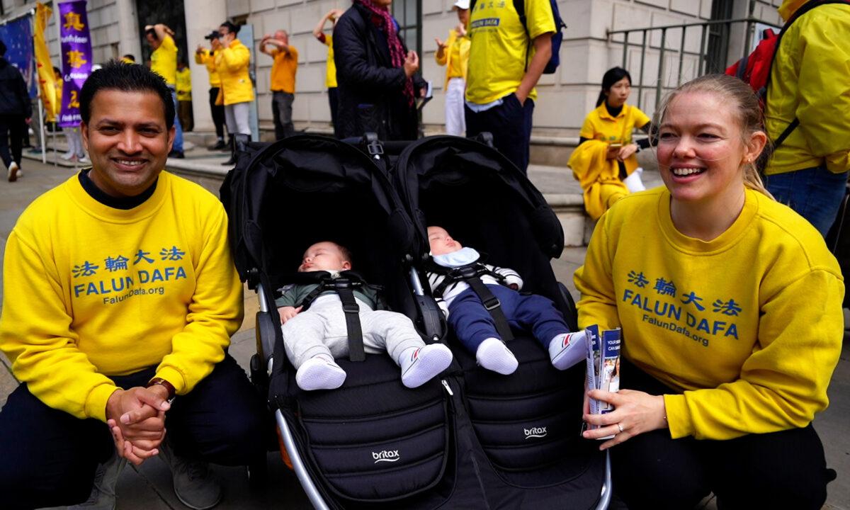 Falun Gong practitioners Racheli Senanayake (R), Lasitha Senanayake, and their six-month-old twin boys during a celebration of World Falun Dafa Day in central London on May 10, 2021. (Jeff Zhang/NTD/Screenshot)