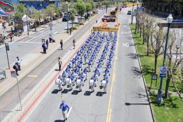 The Tian Guo Marching Band passes by Pier 39 in a parade to celebrate World Falun Dafa Day in San Francisco on May 8, 2021. (David Lam/The Epoch Times)