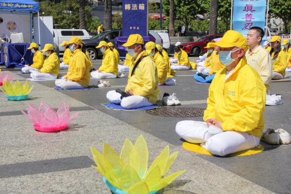 Bay Area Falun Gong practitioners meditate in front of the Ferry Building before a parade to celebrate World Falun Dafa Day in San Francisco on May 8, 2021. (David Lam/The Epoch Times)