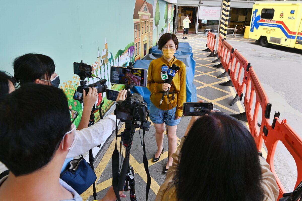 Sarah Liang, a reporter for the Hong Kong edition of The Epoch Times, speaks to local media outside of the Queen Elizabeth Hospital in Hong Kong on May 11, 2021. (Song Pi-lung/The Epoch Times)