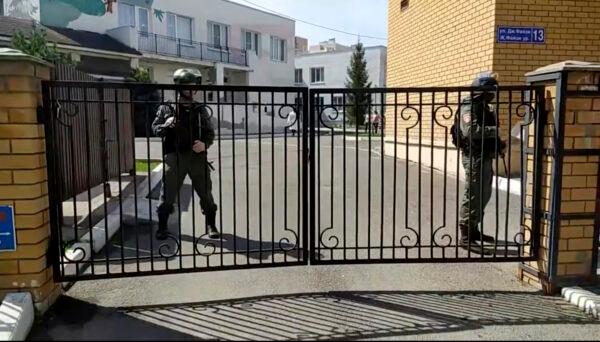 In this image taken from video, police officers guard near the gates of a school after a shooting, in Kazan, Russia, on May 11, 2021. (AP Photo)