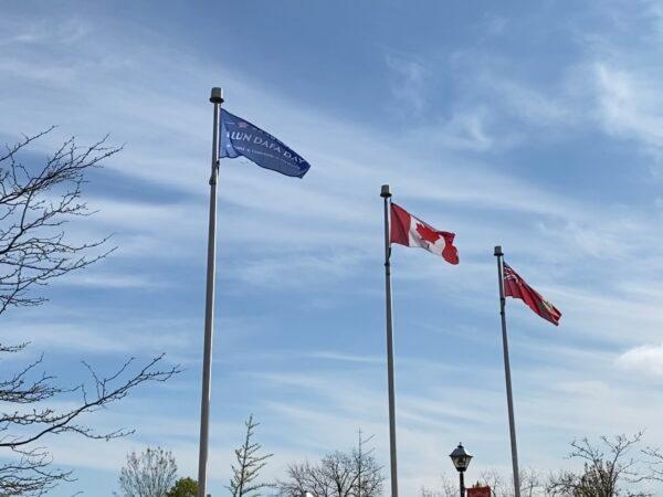 A "Falun Dafa Day" flag sways in the air after being raised by the Niagara Falls City Council ahead of World Falun Dafa Day in Niagara Falls, Canada, on May 8, 2021. (The Epoch Times)