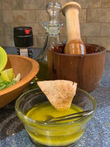 Tasting the dressing for seasoning with a piece of pita. (Courtesy of Valerie A. Winters)