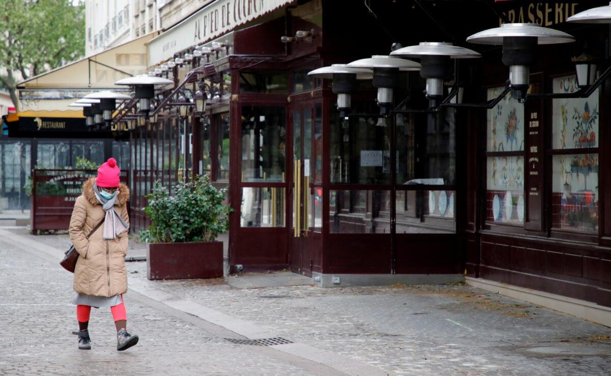 A woman, wearing a protective face mask, walks past a closed restaurant in Paris amid the coronavirus disease (COVID-19) outbreak in France, on May 6, 2021. (Sarah Meyssonnier/Reuters)
