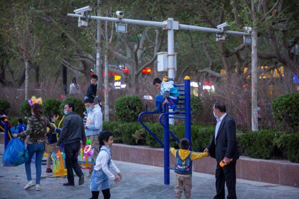 Children play on a playground near security cameras at a public square in Aksu, Xinjiang Uyghur Autonomous Region, China, on April 20, 2021. (Mark Schiefelbein/AP Photo)