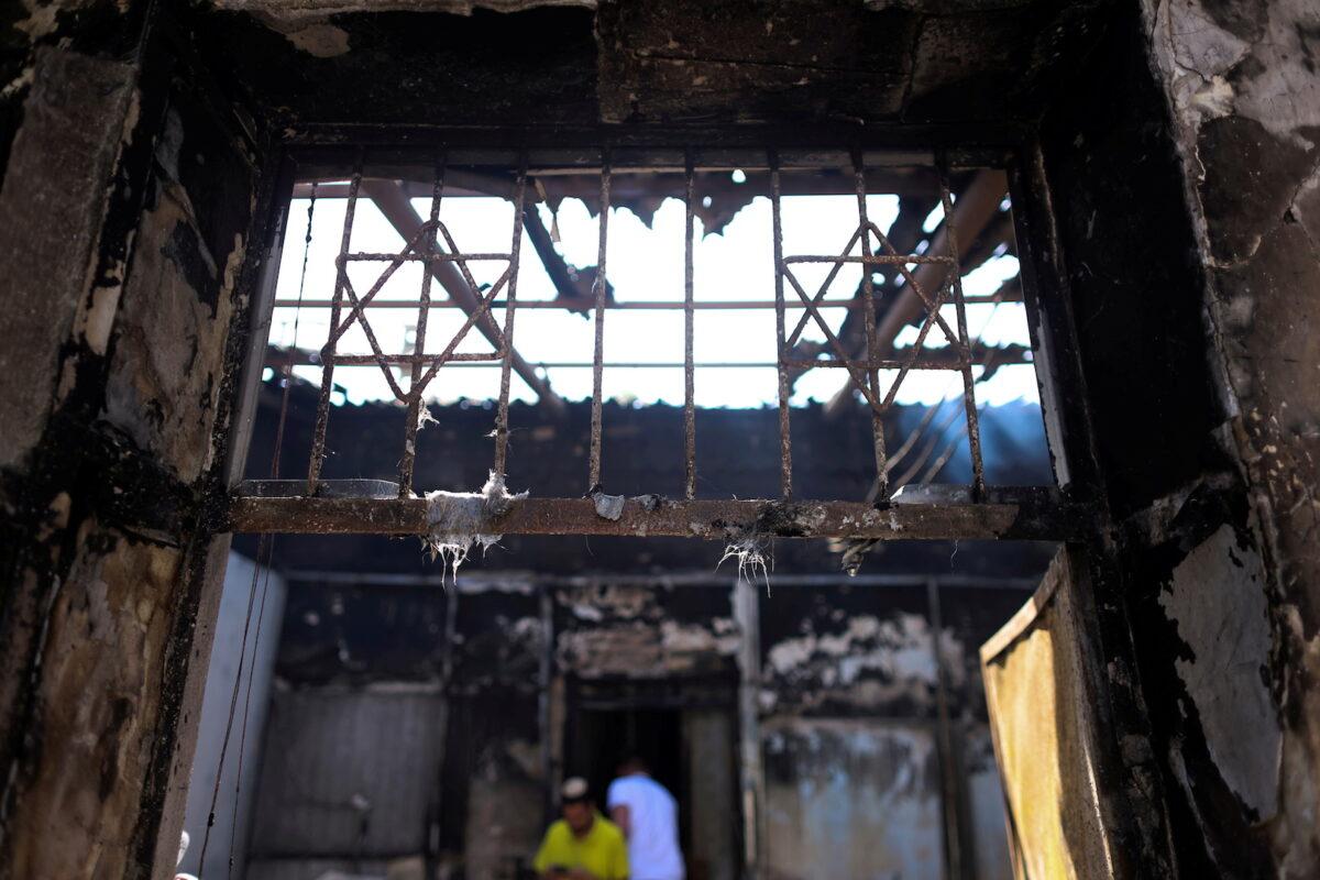 A man walks inside a synagogue that was torched during violent confrontations in the city of Lod, Israel between Israeli Arab demonstrators and police, amid high tensions over hostilities between Israel and Gaza militants and tensions in Jerusalem on May 12, 2021. (Ronen Zvulun/Reuters)
