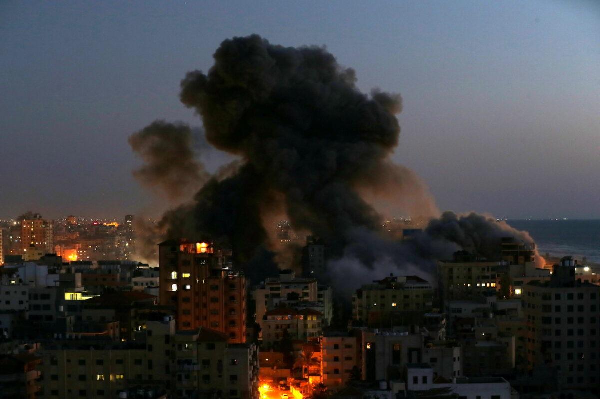 Smoke rises from a building after it was destroyed by Israeli airstrikes amid a flare-up of Israeli-Palestinian violence, in Gaza, on May 11, 2021. (Ibraheem Abu Mustafa/Reuters)