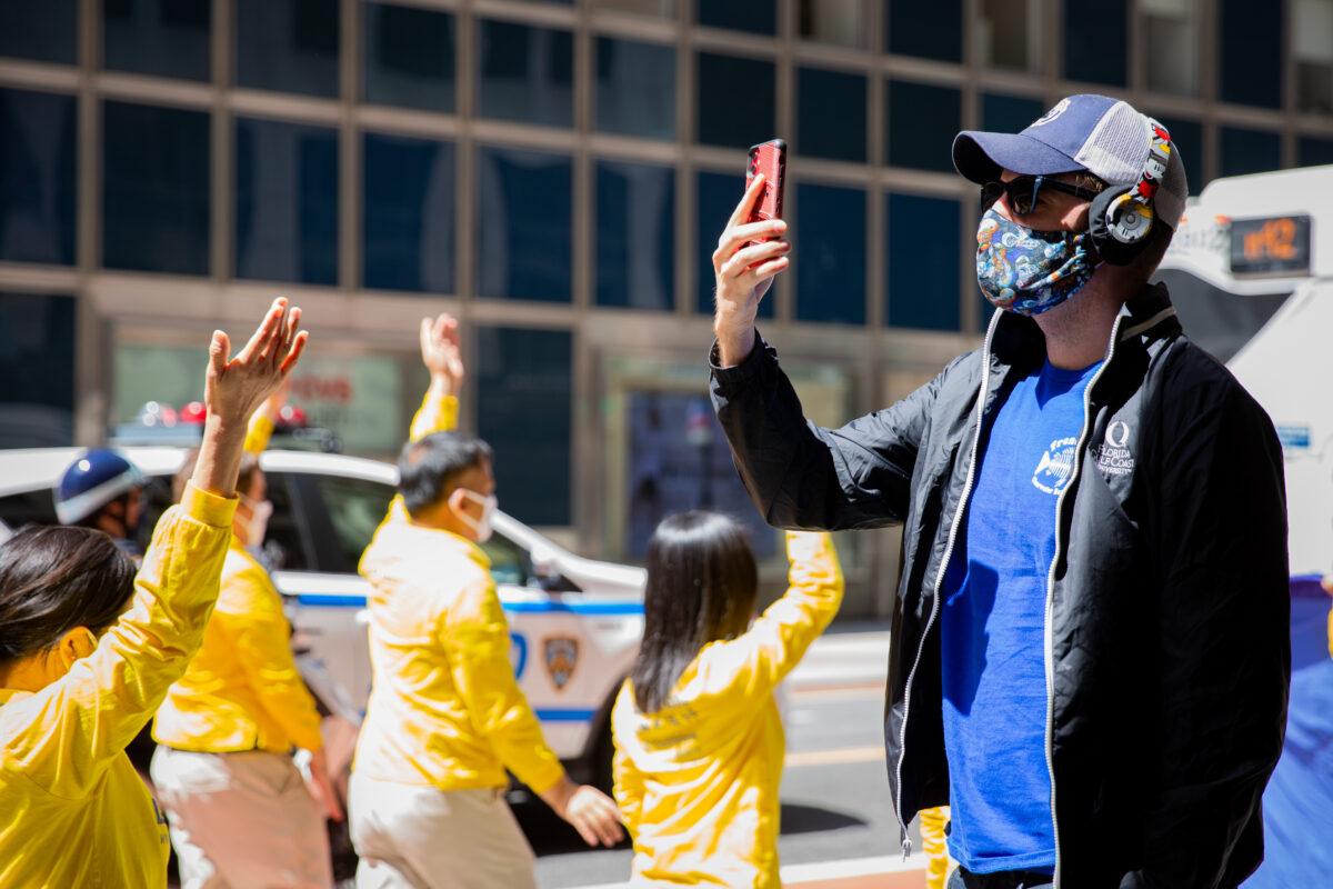 Bystanders watch a parade by practitioners of the spiritual discipline Falun Gong in New York on May 13, 2020. (Chung I Ho/The Epoch Times)
