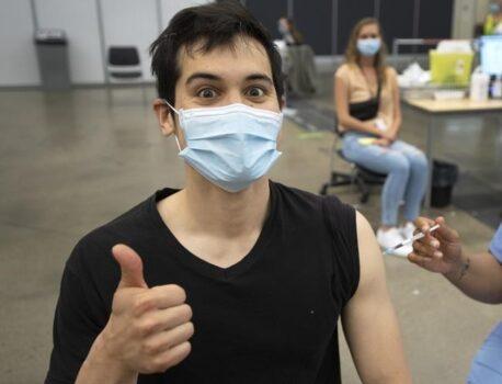 Adam Feller reacts as he gets his Pfizer-BioNTech shot at a COVID-19 vaccination clinic on May 13, 2021, in Montreal. Quebec has become the latest province to stop giving Oxford-AstraZeneca COVID-19 shot as a first dose. (Ryan Remiorz/The Canadian Press)