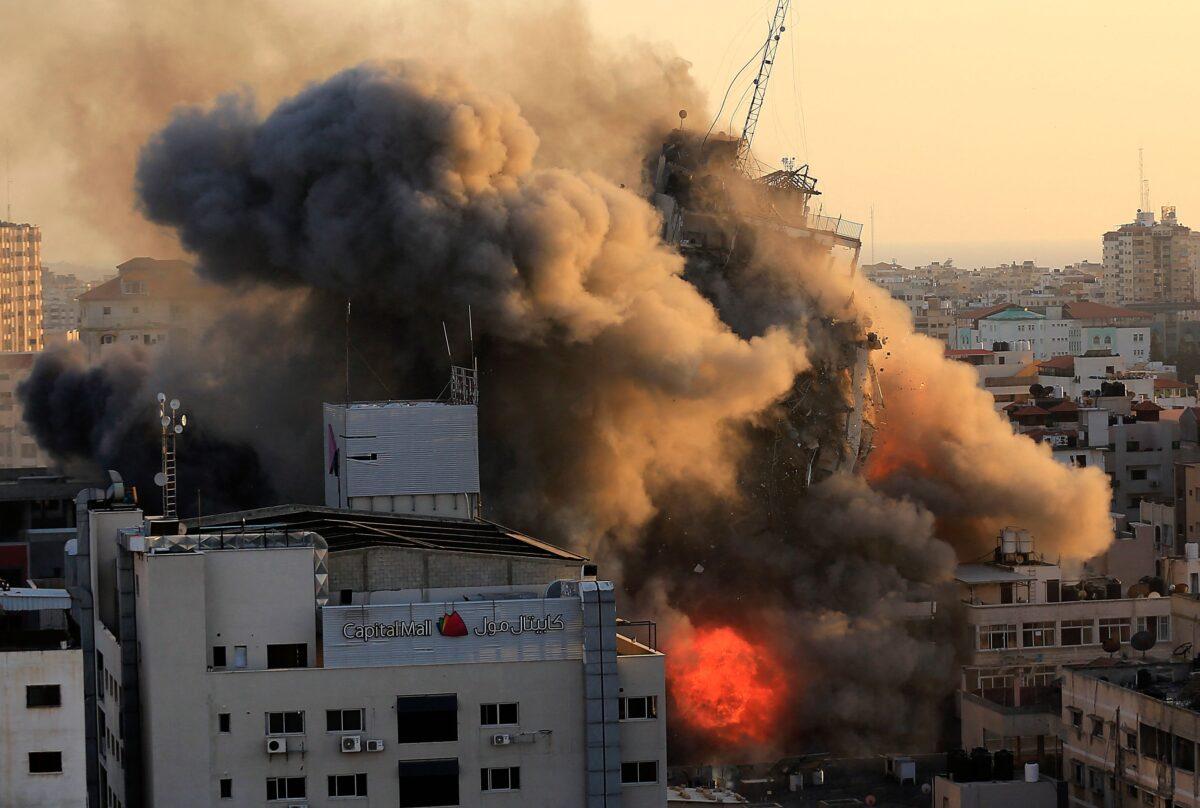 Heavy smoke and fire surround the Al-Sharouk tower as it collapses during an Israeli airstrike, in Gaza City on May 12, 2021. (QUSAY DAWUD/AFP via Getty Images)