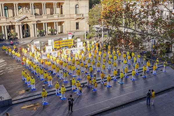 Falun Gong practitioners gathered for morning exercise in front of the Customs House adjacent to the Sydney Opera House in Sydney, Australia on May 13, 2021. (Yi Luoxun/The Epoch Times)