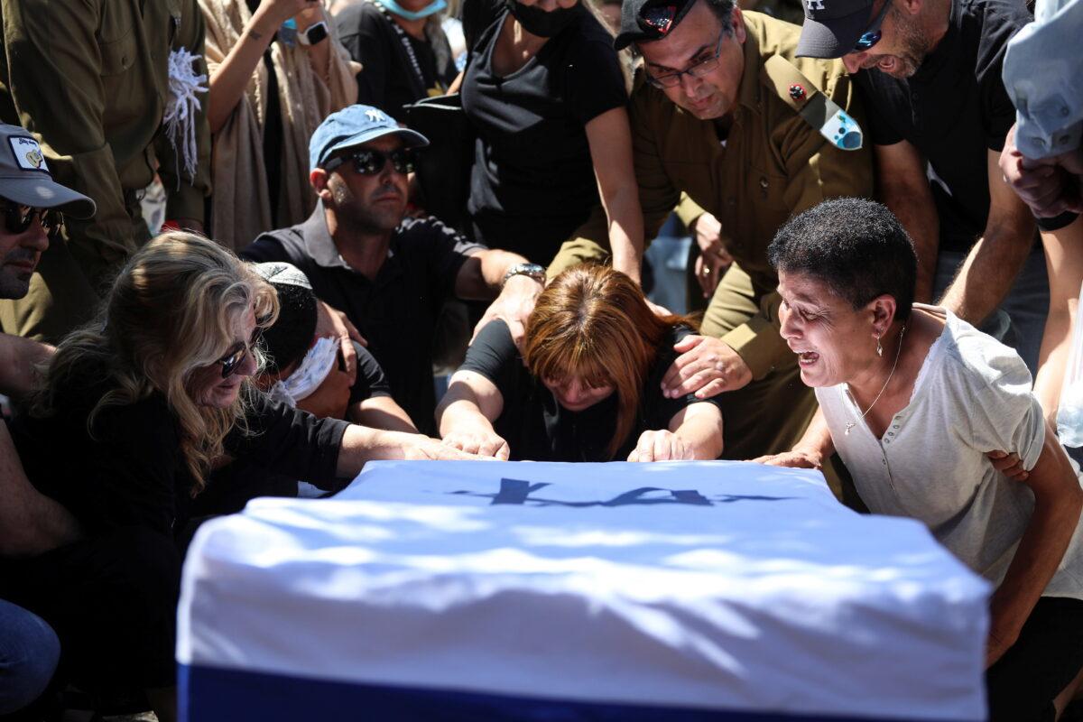 Family and friends, including Israeli soldiers, mourn over the flag-covered coffin of Israeli soldier Omer Tabib, who was killed during cross-border fighting with Gaza, at his funeral in Eliakim, Israel, on May 13, 2021. (Avishag Shar-Yashuv/Reuters)