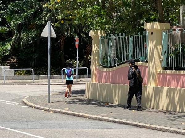 The man, wearing black dark clothing, run to Sarah Liang and a black bat fell out from his jacket when she was waiting for a bus in Hong Kong on May 8, 2021. (Sarah Liang/The Epoch Times)