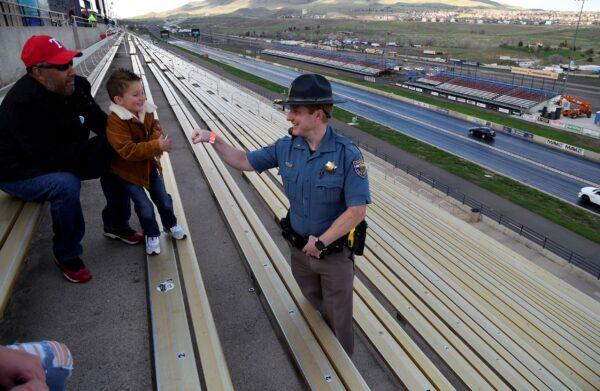Colorado State Patrol Trooper Josh Lewis fist bumps 3-year-old Lincoln Delagarza, of Northglenn, Colorado, before racing begins at Bandimere Speedway west of Denver, Colo., on May 5, 2021. (Thomas Peipert/AP Photo)