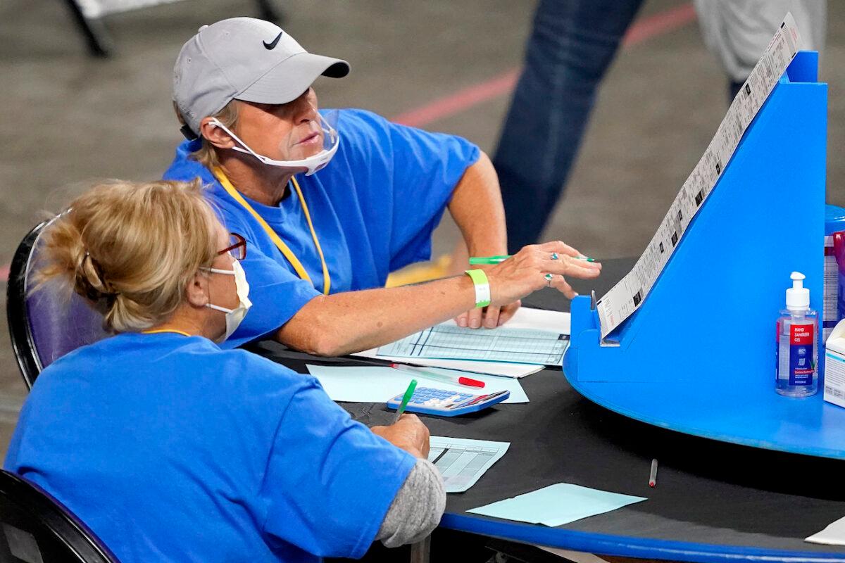Maricopa County ballots cast in the 2020 General Election are examined and recounted by contractors working for Florida-based company, Cyber Ninjas, at Veterans Memorial Coliseum in Phoenix, Ariz., on May 6, 2021. (Matt York/Pool/AP Photo)