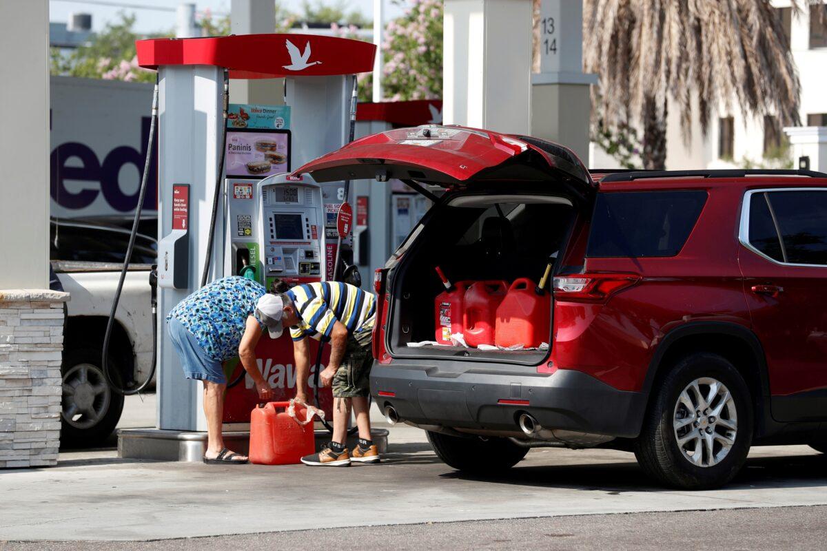 A couple fills up multiple 5 gallon gas tanks at a Wawa gas station in Tampa, Fla., on May 12, 2021. (Octavio Jones/Reuters)
