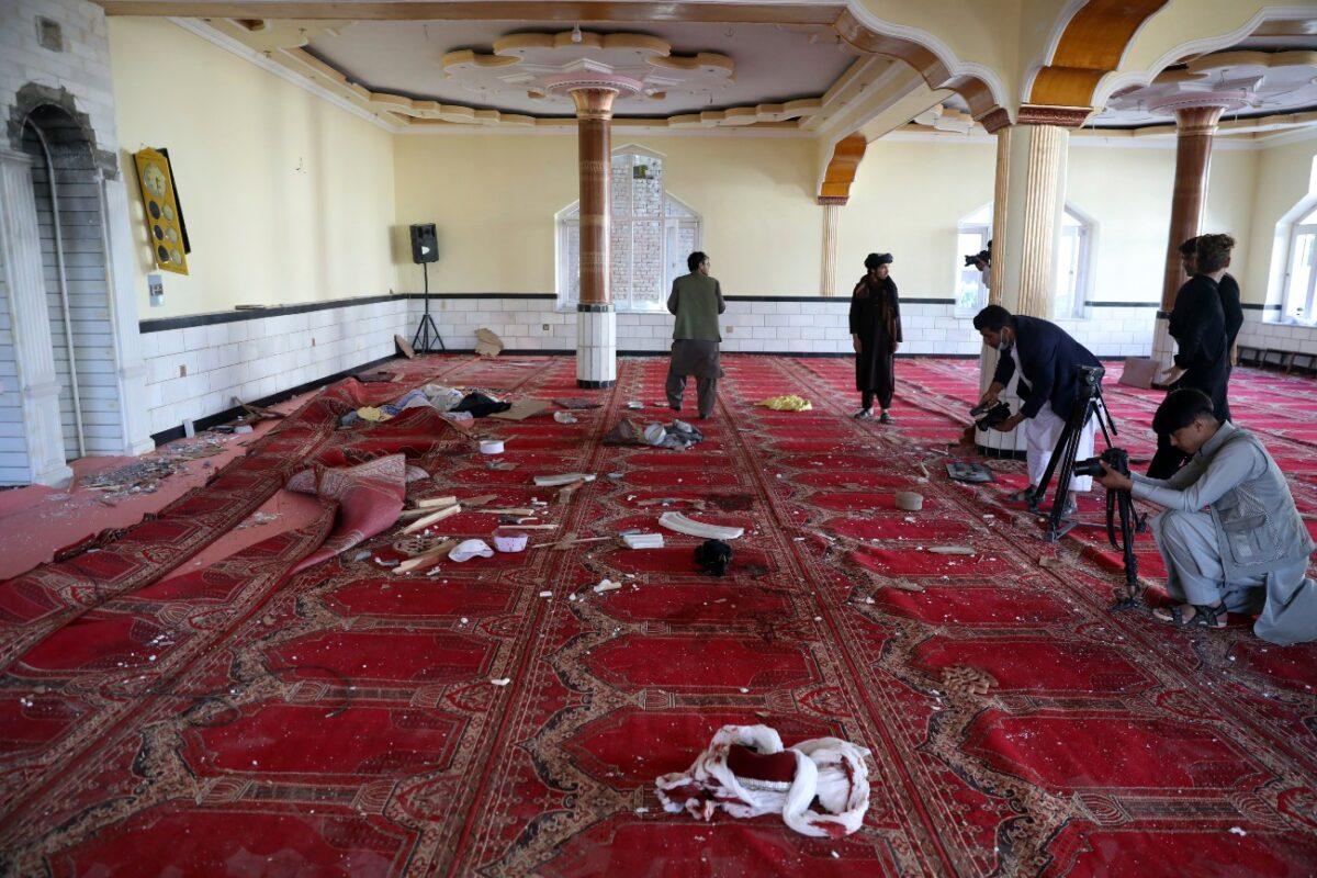Afghan journalist take photos and film inside a mosque after a bomb explosion in Shakar Dara district of Kabul, Afghanistan, on May 14, 2021. (Rahmat Gul/AP Photo)