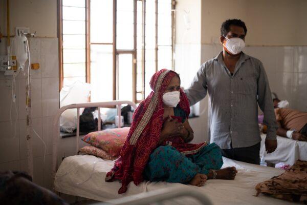 An Indian relative comforts a patient as she receives treatment for the coronavirus at the Kapil Government Hospital, which became a coronavirus consultation and treatment facility serving villages in the Jaipur and Sikar districts, on May 15, 2021 in Rajasthan, India. (Rebecca Conway/Getty Images)