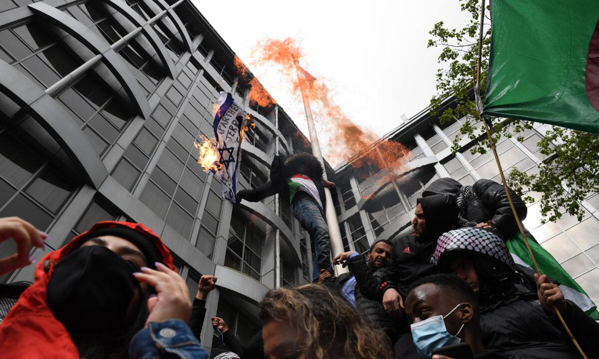 Protesters burn an Israeli flag outside the Israeli Embassy in London, on May 15, 2021. (Chris J Ratcliffe/Getty Images)