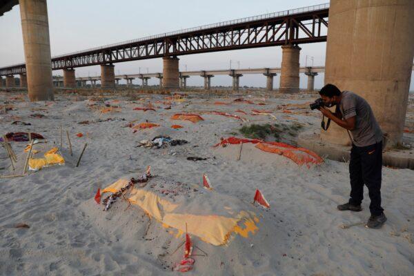 Bodies of suspected COVID-19 victims are seen in shallow graves buried in the sand near a cremation ground on the banks of Ganges River in Prayagraj, India, on May 15, 2021. (Rajesh Kumar Singh/AP Photo)