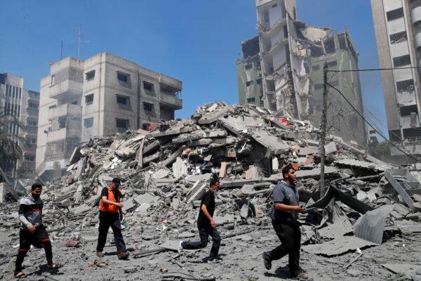 People inspect the rubble of a building destroyed in an Israeli airstrike, in Gaza City, on May 16, 2021. (Adel Hana/AP Photo)