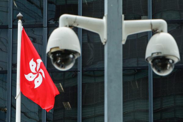 A Hong Kong flag is flown behind a pair of surveillance cameras outside the Central Government Offices in Hong Kong on July 20, 2020. (Tyrone Siu/Reuters)