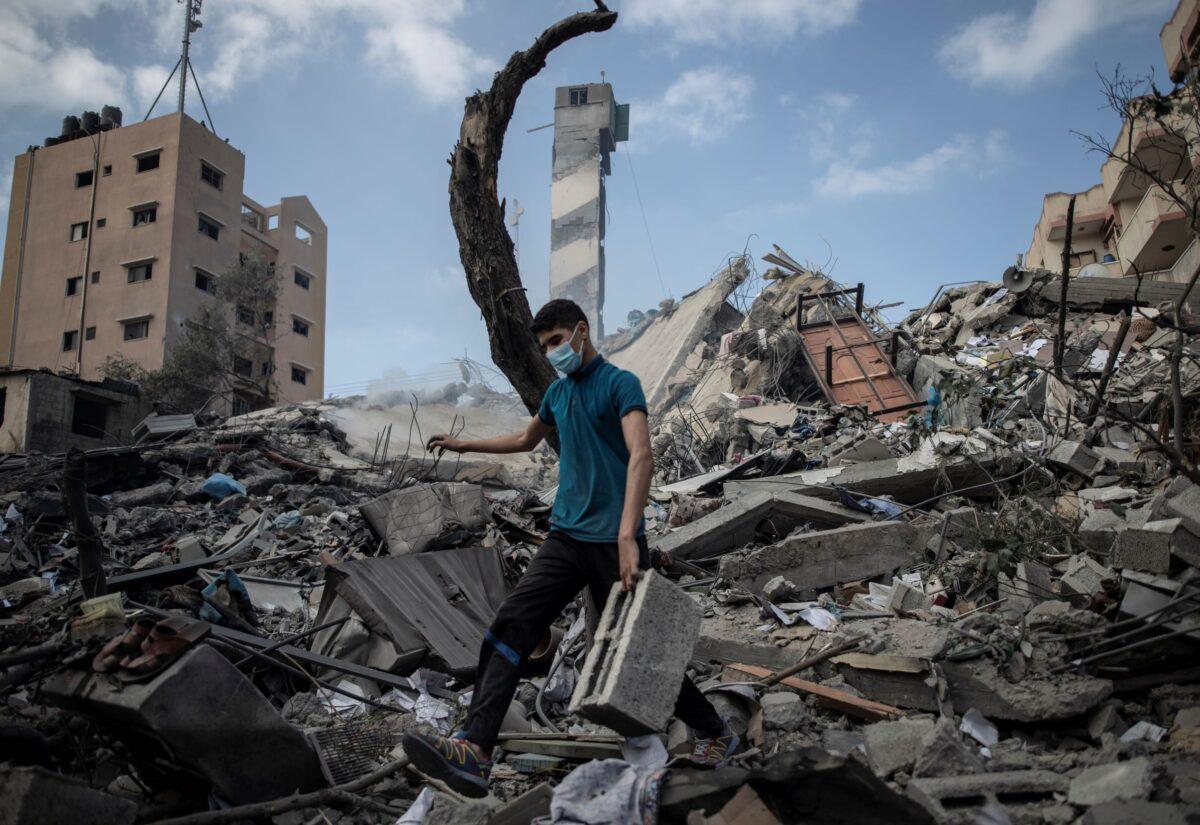 A Palestinian man inspects the damage of a six-story building that was destroyed by an early morning Israeli airstrike, in Gaza City, on May 18, 2021. (Khalil Hamra/AP Photo)