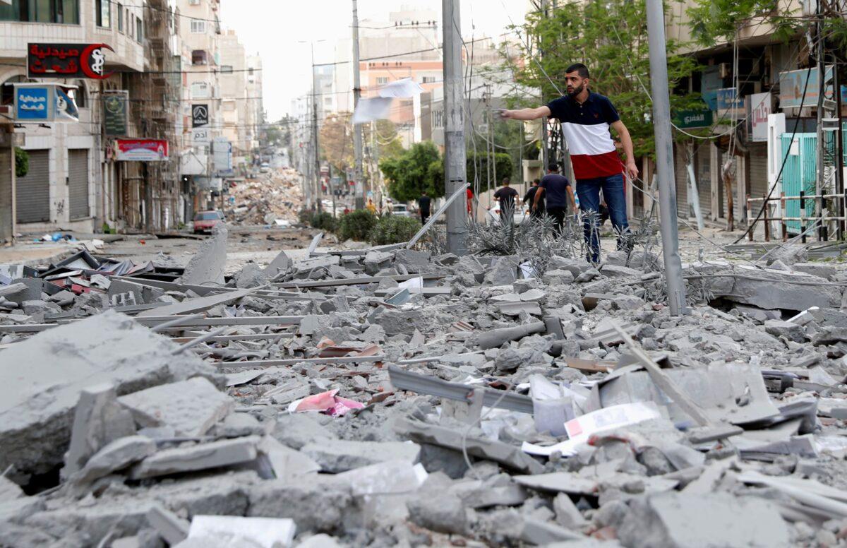 A man inspects the rubble of a destroyed commercial building and Gaza health care clinic following an Israeli airstrike on the upper floors of a commercial building near the Health Ministry in Gaza City, on May 17, 2021. (Adel Hana/AP Photo)