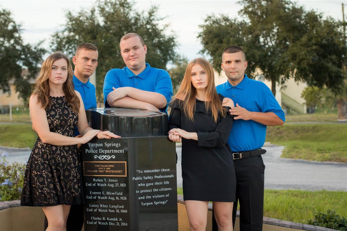 Aleena (R) and her siblings stand next to the obituary pole with their dad's name. (Courtesy of <a href="https://www.facebook.com/teresa.kondek">Teresa Kondek</a>)