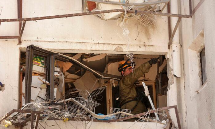 An Israeli soldier inspects damage to an apartment in a residential building after it was hit by a rocket fired from the Gaza Strip, in Ashdod, southern Israel, on May 17, 2021. (Maya Alleruzzo/AP Photo)