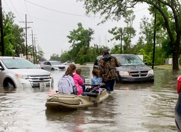 Parents use boats to pick up students from schools after nearly a foot of rain fell in Lake Charles, La., on May 17, 2021. (Rick Hickman/American Press via AP)