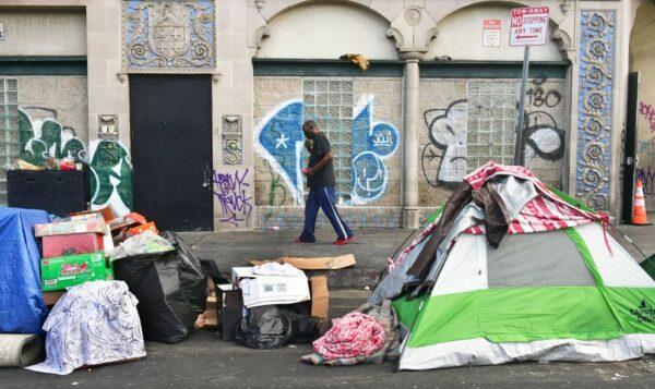 A man walks past tents housing the homeless on the streets in the Skid Row community of Los Angeles, on April 26, 2021. (Frederic J. Brown/AFP via Getty Images)