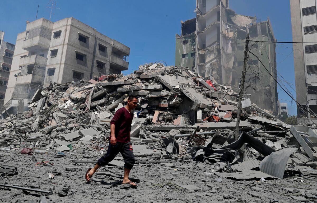 A man walks past the rubble of the Yazegi residential building that was destroyed by an Israeli airstrike, in Gaza City on May 16, 2021. (Adel Hana/AP Photo)