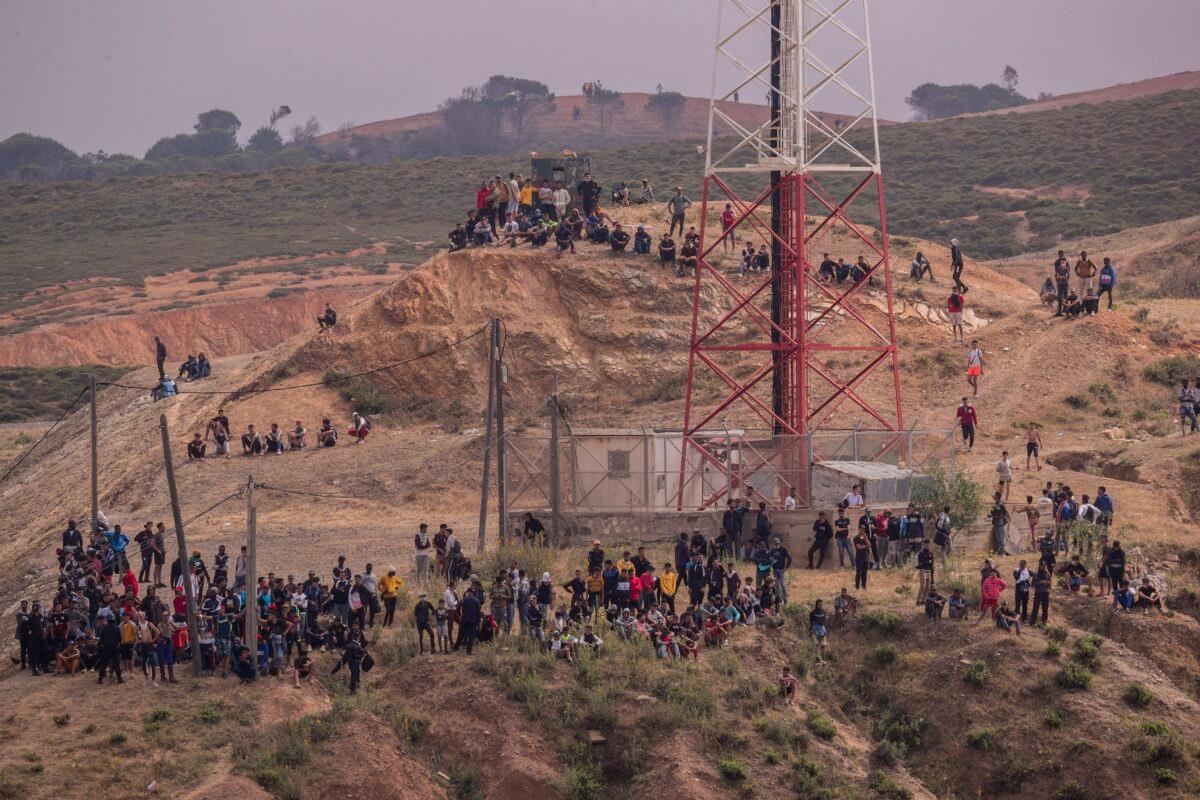 Migrants trying to reach the Spanish enclave of Ceuta wait on the Morocco side of the border, on May 19, 2021. (Bernat Armangue/AP Photo)