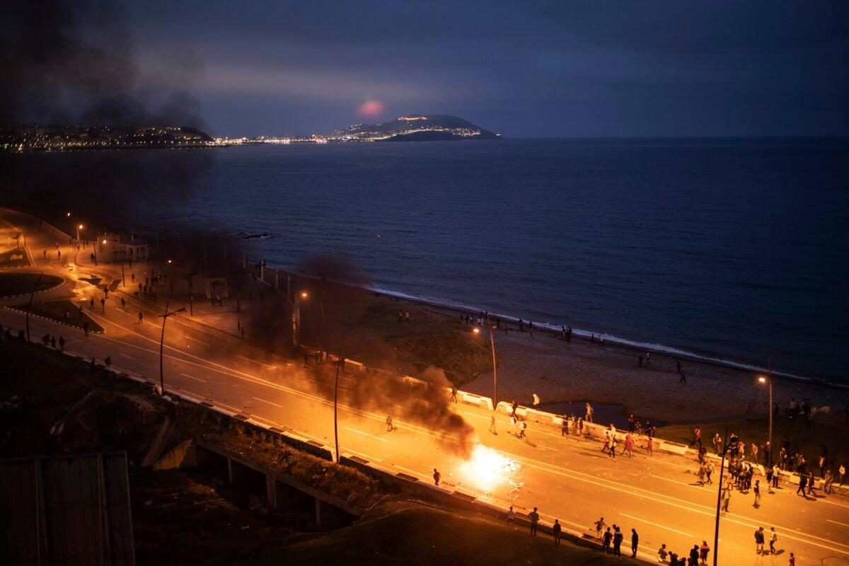 Moroccan youth clash with Moroccan security forces as they try to cross to the Spanish enclave of Ceuta, in Fnideq, Morocco, on May 19, 2021. (Mosa'ab Elshamy/AP Photo)