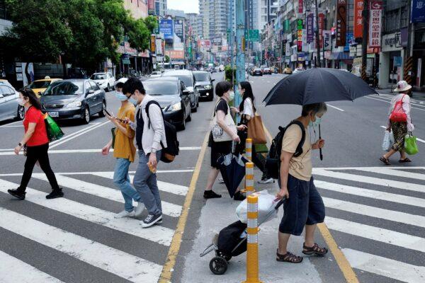 Pedestrians wear protective masks after a new wave of COVID-19 pandemic occurred in New Taipei city on May 15, 2021. (Sam Yeh/AFP via Getty Images)