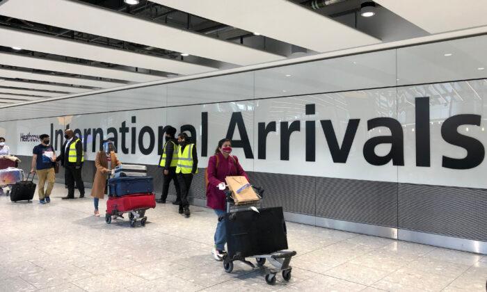 Passengers are escorted through the arrivals area of terminal 5 towards coaches destined for quarantine hotels, after landing at Heathrow airport in London on April 23, 2021. (Leon Neal/Getty Images)