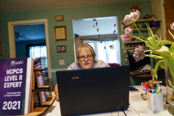 Ellen Booth, 57, studies at her kitchen table to become a certified medical coder, in Coventry, R.I., on May 17, 2021. (David Goldman/AP Photo)