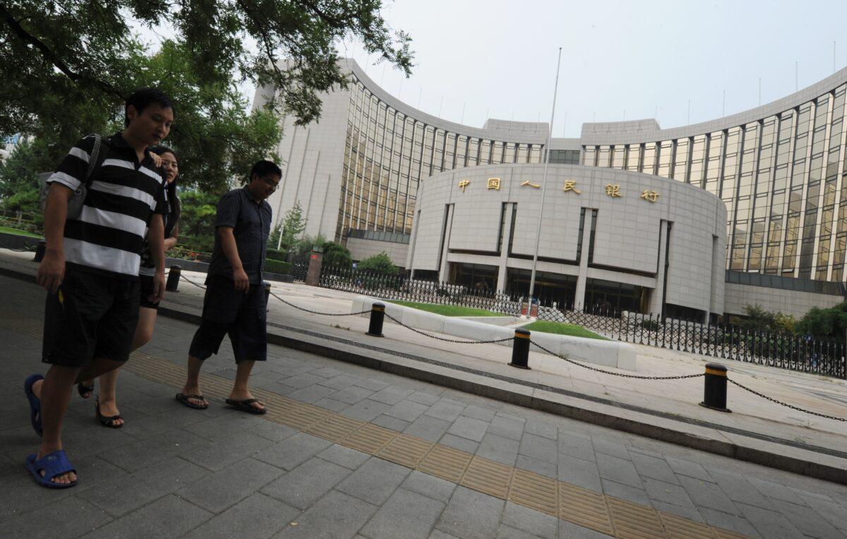 Shoppers walk outside the headquarters of the Chinese central bank in Beijing on Aug. 7, 2011. (Mark Ralston/AFP via Getty Images)