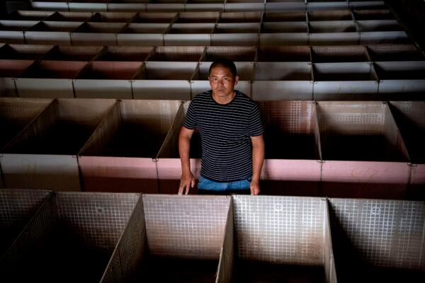 Bamboo rat farmer Huang Guohua posing amongst empty bamboo rat cages in Shaoyang in central China's Hunan Province, on Aug. 14, 2020. (Noel Celis/AFP via Getty Images)
