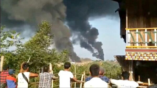 People look at thick columns of black smoke from Hkamti, Sagaing, Burma, on May 22, 2021.(News Anassador via Reuters)