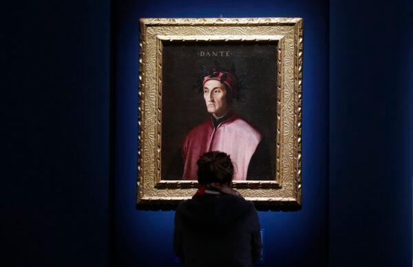 A woman looks at a portrait of poet Dante Alighieri, by an 18th-century Florentine anonymous painter, at the "Dante. La visione dell'arte" (Dante. The Vision of Art) exhibition, in Forli, Italy, on May 8, 2021. (Antonio Calanni/AP Photo)