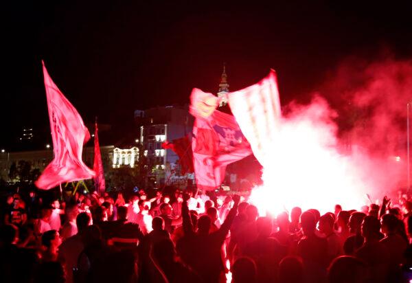 Red Star fans celebrate after their team won the Serbian soccer league title in Belgrade, Serbia, on May 22, 2021. (Darko Vojinovic/AP Photo)