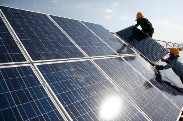 Workers install solar panels at a photovoltaic power station in Hami in northwestern China's Xinjiang Uyghur Autonomous Region on Aug. 22, 2011. (Chinatopix via AP)