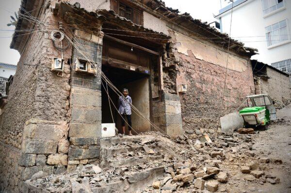 A woman looks out from a building damaged by an overnight earthquake in Yangbi County of Dali Prefecture, in China's southwest Yunnan province on May 22, 2021. (AFP via Getty Images)