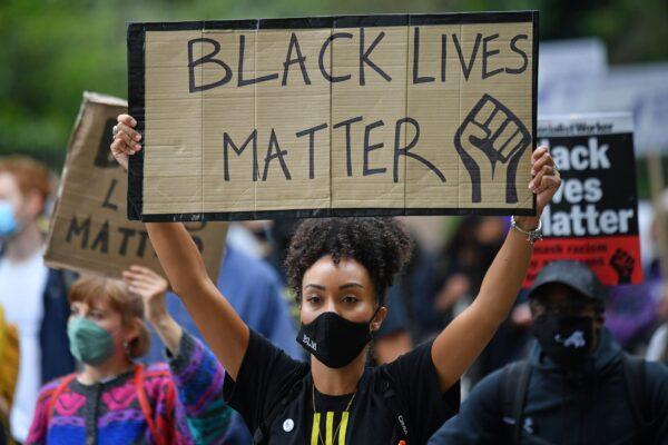 People hold up placards in support of the Black Lives Matter movement, as they take part in the inaugural Million People March in London to put pressure on the UK government to change the UK's institutional and systemic racism, on Aug. 30, 2020. (Justin Tallis/AFP via Getty Images)